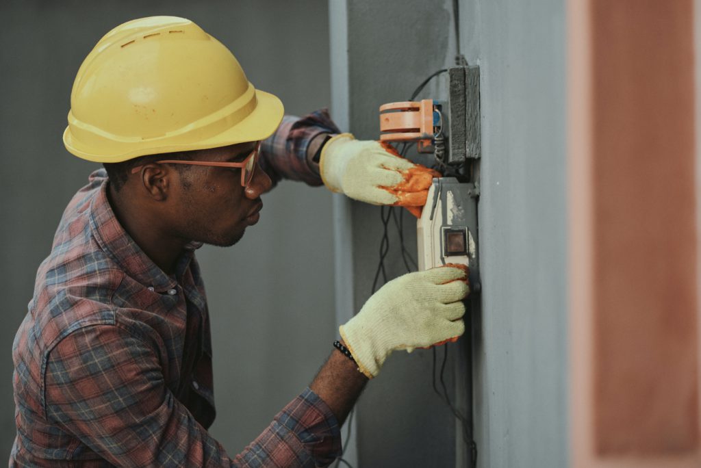 man in brown hat holding black and gray power tool